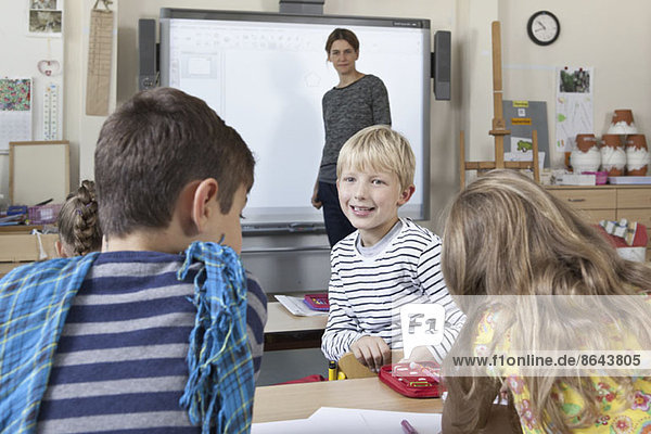 Boy in classroom talking with students