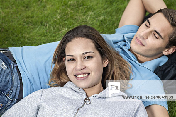 Junges Paar auf Gras liegend