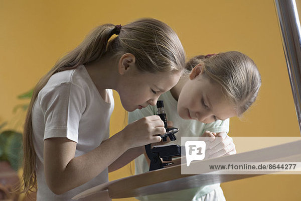 Mädchen beim Blick durchs Mikroskop