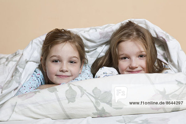 Portrait of girls relaxing on bed