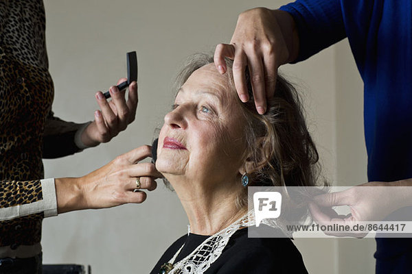 Make-up Artist beim Auftragen von Kompaktpuder auf das Gesicht der Frau