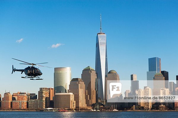 Helicopter flying over river  New York  USA