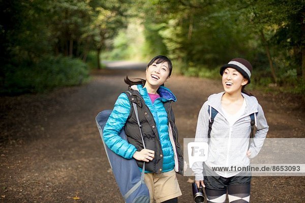 Two young female hikers on country road