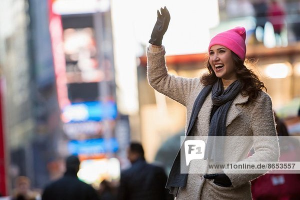Young female tourist waving from street  New York City  USA