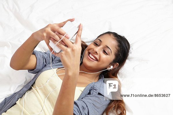 Junge Frau hört Musik im Schlafzimmer