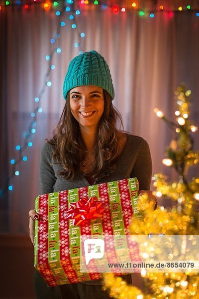 Porträt einer jungen Frau mit Weihnachtsgeschenk