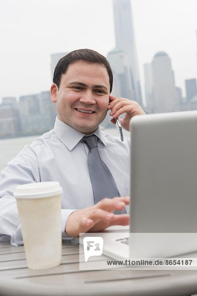 Businessman using laptop outdoors  Jersey City  New Jersey  USA