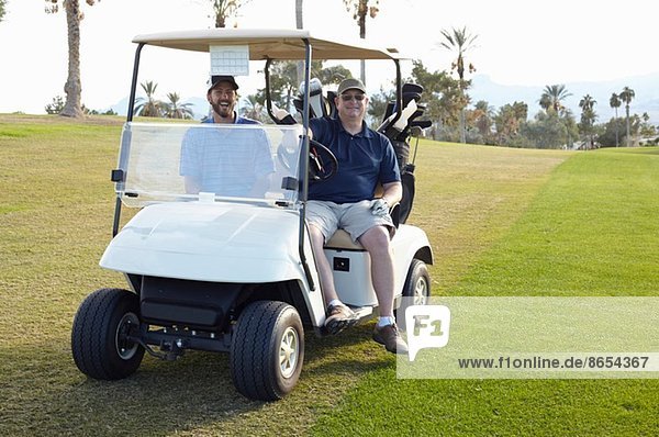 Portrait von zwei männlichen Golfern im Golf-Buggy