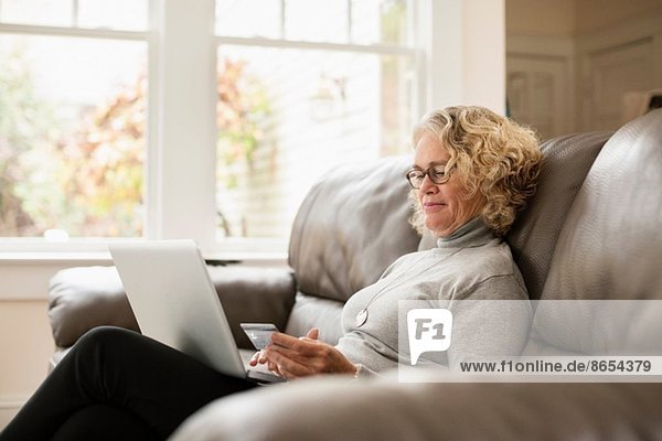 Senior Frau online einkaufen auf dem Laptop