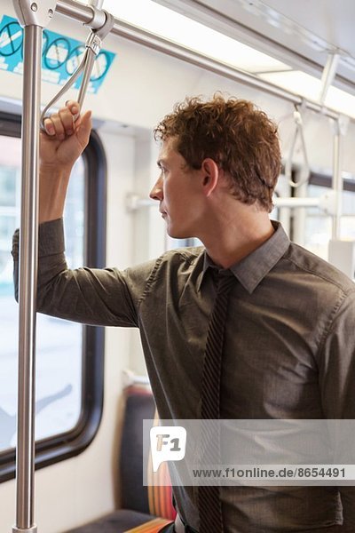 Mid adult businessman staring out of train carriage window