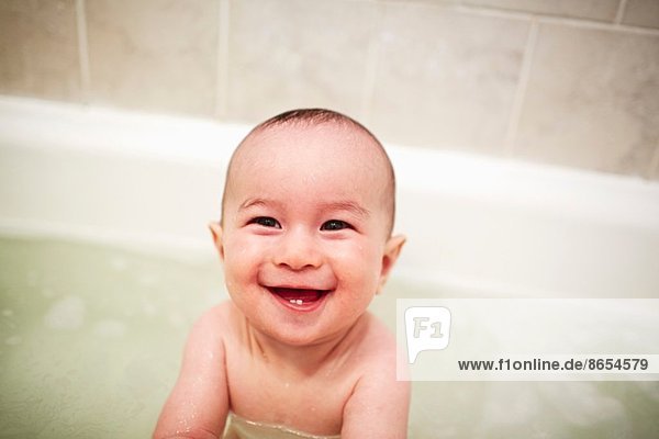 Portrait of baby boy enjoying a bath