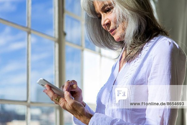 Seniorin mit Touchscreen auf dem Smartphone