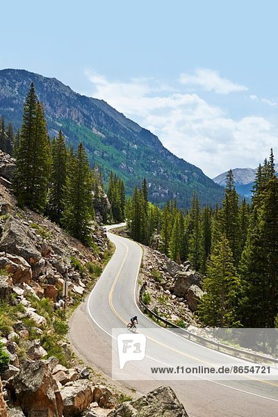 Cyclist on winding highway  Aspen  Colorado  USA
