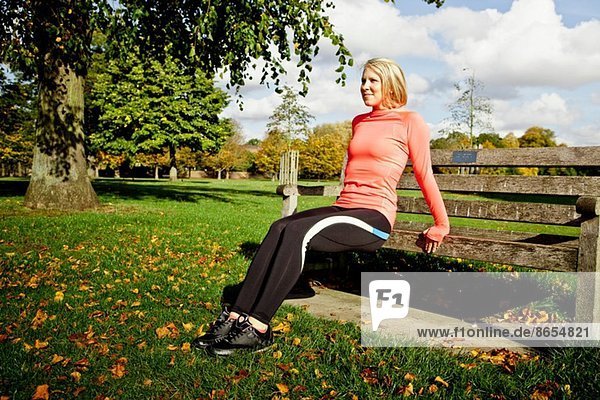Frau beim Training auf der Parkbank