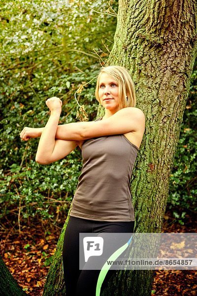 Woman stretching arms in woods