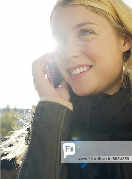 Junge Frau im Freien spricht auf dem Handy