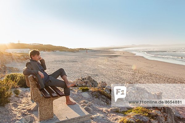 Man relaxing on beach bench