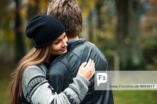 Young couple hugging in woods