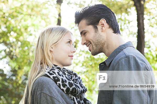 Couple standing together outdoors  looking into each other's eyes