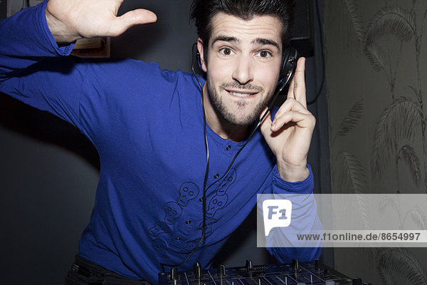 DJ über Kopfhörer und Audiomischer  Portrait