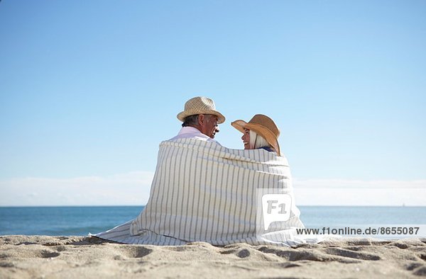Paar mit Strohhut am Strand