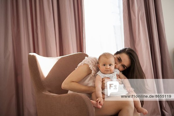 Mutter spielt mit Baby im Sessel
