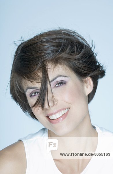 Frau mit kurzem Haar  Haarsträhne vor dem Gesicht  lächelnd  Portrait