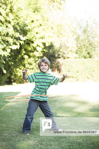 Junge spielt mit Hula-Reifen im Hof