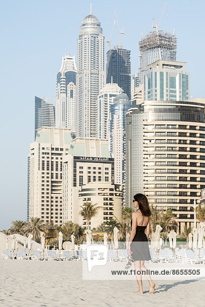 Frau am Strand mit Wolkenkratzern im Hintergrund  Dubai  Vereinigte Arabische Emirate