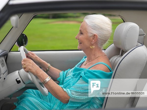 Glamouröse Seniorin beim Autofahren