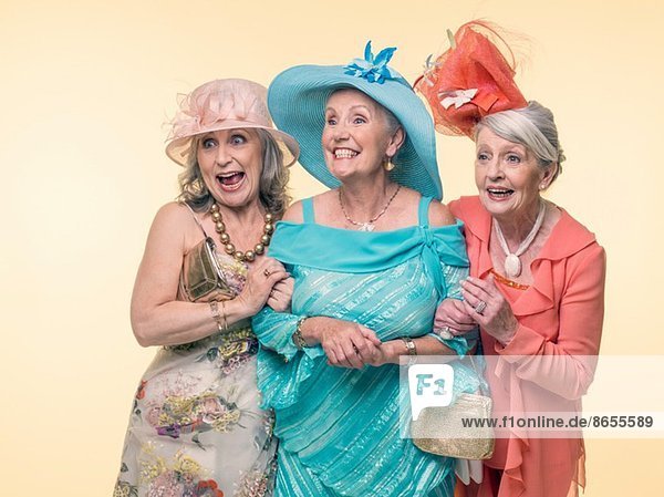 Studio-Porträt von drei glücklichen  glamourösen Seniorinnen