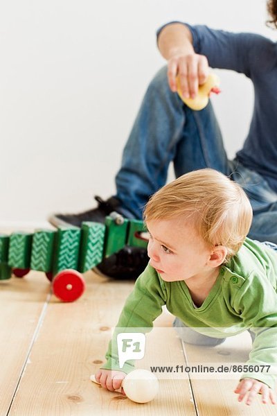 Studioaufnahme von Vater und Tochter beim Spielen auf dem Boden