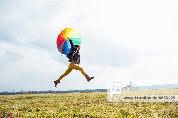 Teenager Mädchen im Feld mit Regenschirm