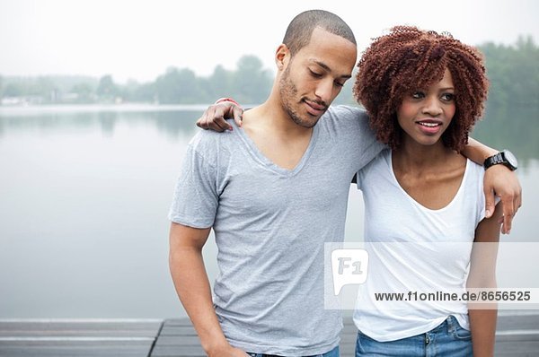 Porträt eines jungen Paares am See mit umlaufenden Armen