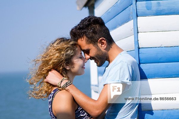 Young couple hugging by beach hut