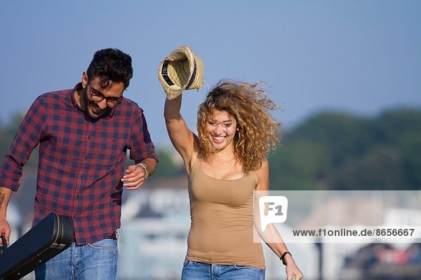 Young couple laughing  woman holding hat