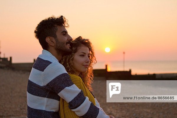 Junges Paar am Strand bei Sonnenuntergang