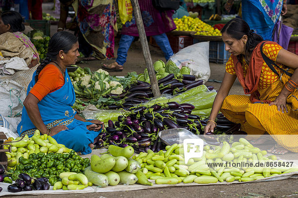 Eine Frau verkauft Auberginen  Paprika  Blumenkohl und Gurken auf dem wöchentlichen Gemüsemarkt  Nasik  Maharashtra  Indien