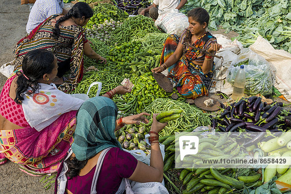 Eine Frau verkauft Auberginen  Paprika  Blumenkohl und Gurken auf dem wöchentlichen Gemüsemarkt  Nasik  Maharashtra  Indien