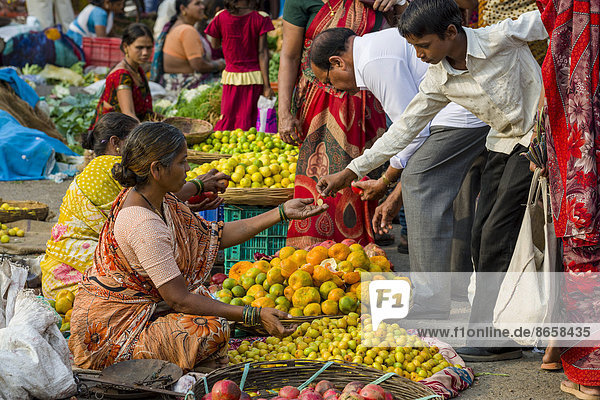 Eine Frau verkauft Orangen und andere Früchte auf dem wöchentlichen Gemüsemarkt  Nasik  Maharashtra  Indien