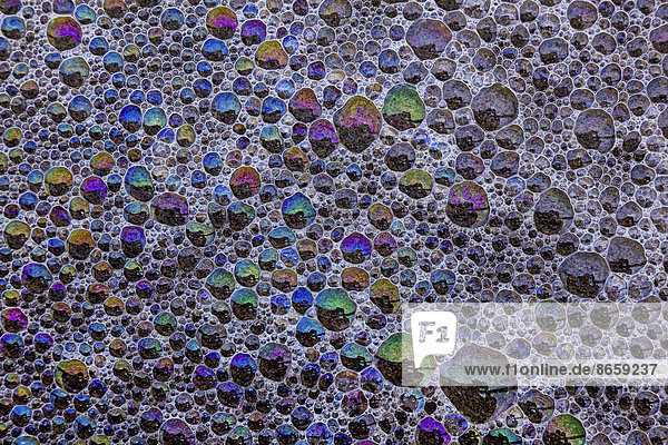 Schaum und Luftblasen reflektieren Regenbogenfarben auf der Oberfläche von Cannon Beach  Oregon  USA
