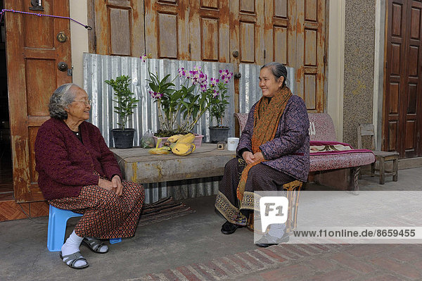 sitzend Frau Wohnhaus frontal Sarong Kleidung typisch Laos Luang Prabang