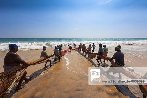 Fishermen  day labourers  hauling in a net on the beach  near Kottegoda  Southern Province  Sri Lanka