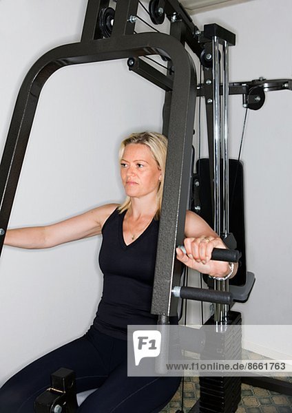 Frau mit Trainingsgeräten im Fitness-Studio