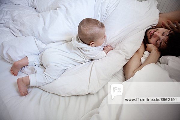 Father with baby son in bed  London  United Kingdom