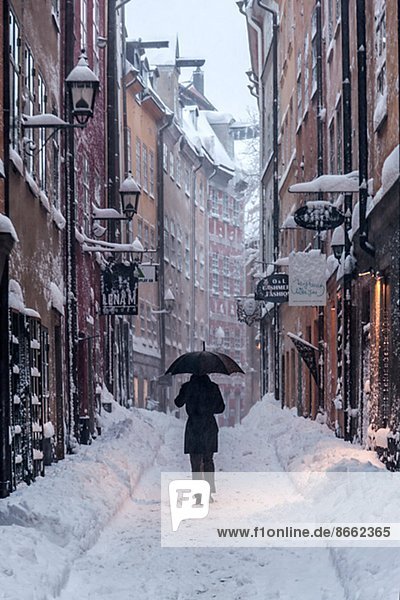 Person walking through snowy street  Stockholm Old Town  Stockholm  Sweden