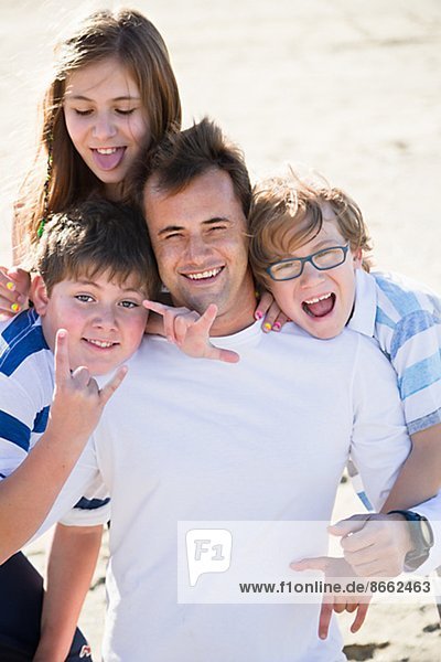 Vater mit Kindern am Strand