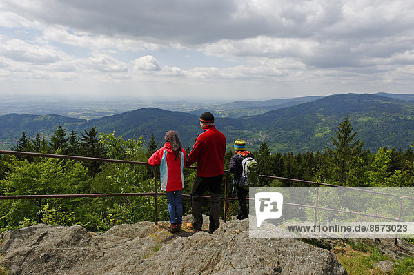 Hikers enjoying the view of the Danube plain from Kreuzfelsen peak  Dreitannenriegel mountain  near Grafling  Bavarian Forest  Bavaria  Lower Bavaria  Germany