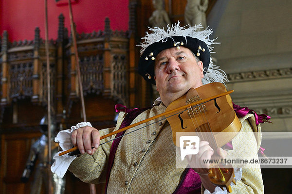 Musician in period costume performing on a medieval fiddle  Edinburgh Castle  Edinburgh  Scotland  United Kingdom