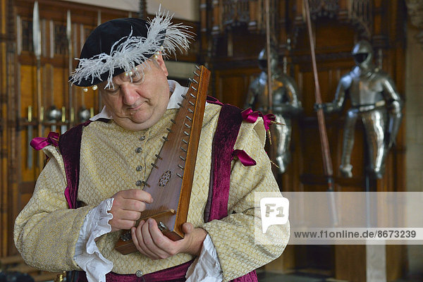 Musician in period costume performing on a medieval psaltery  Edinburgh Castle  Edinburgh  Scotland  United Kingdom
